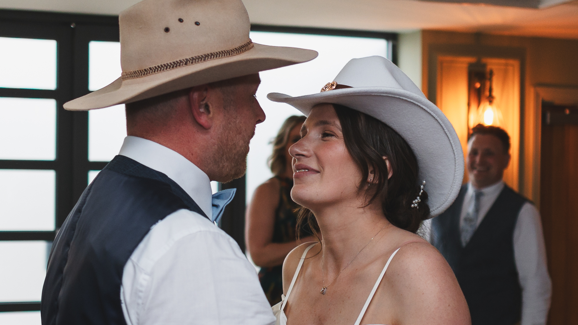 Bride and groom wearing cowboy hats during fun wedding reception dance at rustic Yorkshire wedding venue