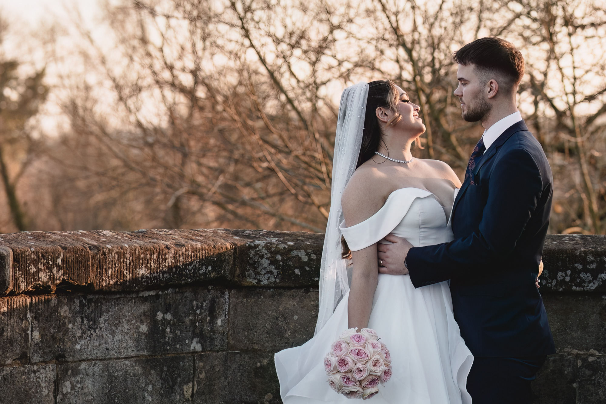 Elegant bride and groom portrait on a historic stone bridge during a romantic Yorkshire wedding day.