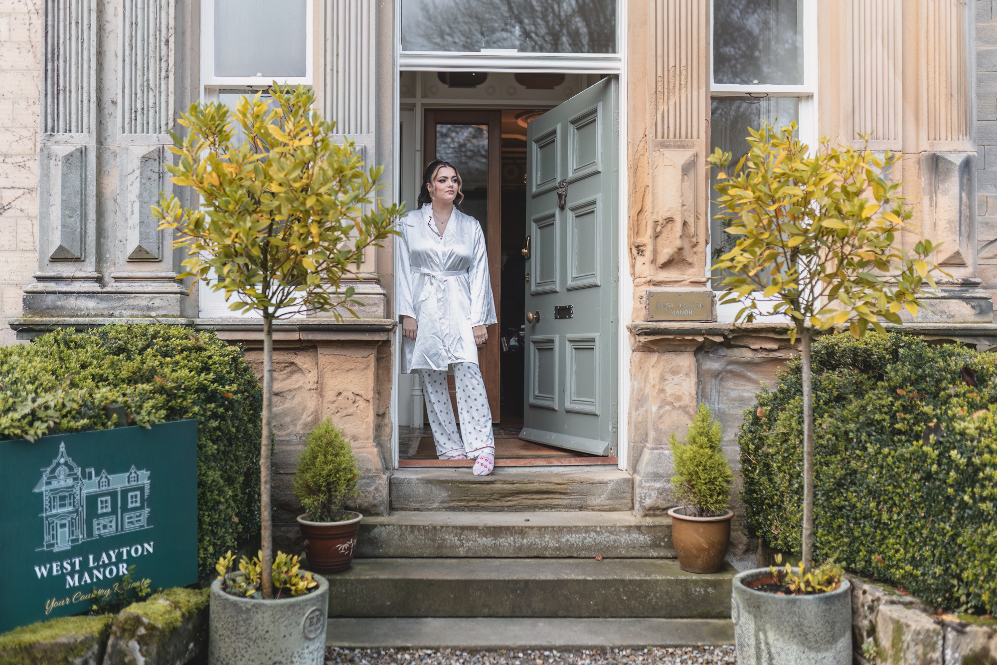 Bride standing at the entrance of West Layton Manor during morning preparations for a Yorkshire wedding.