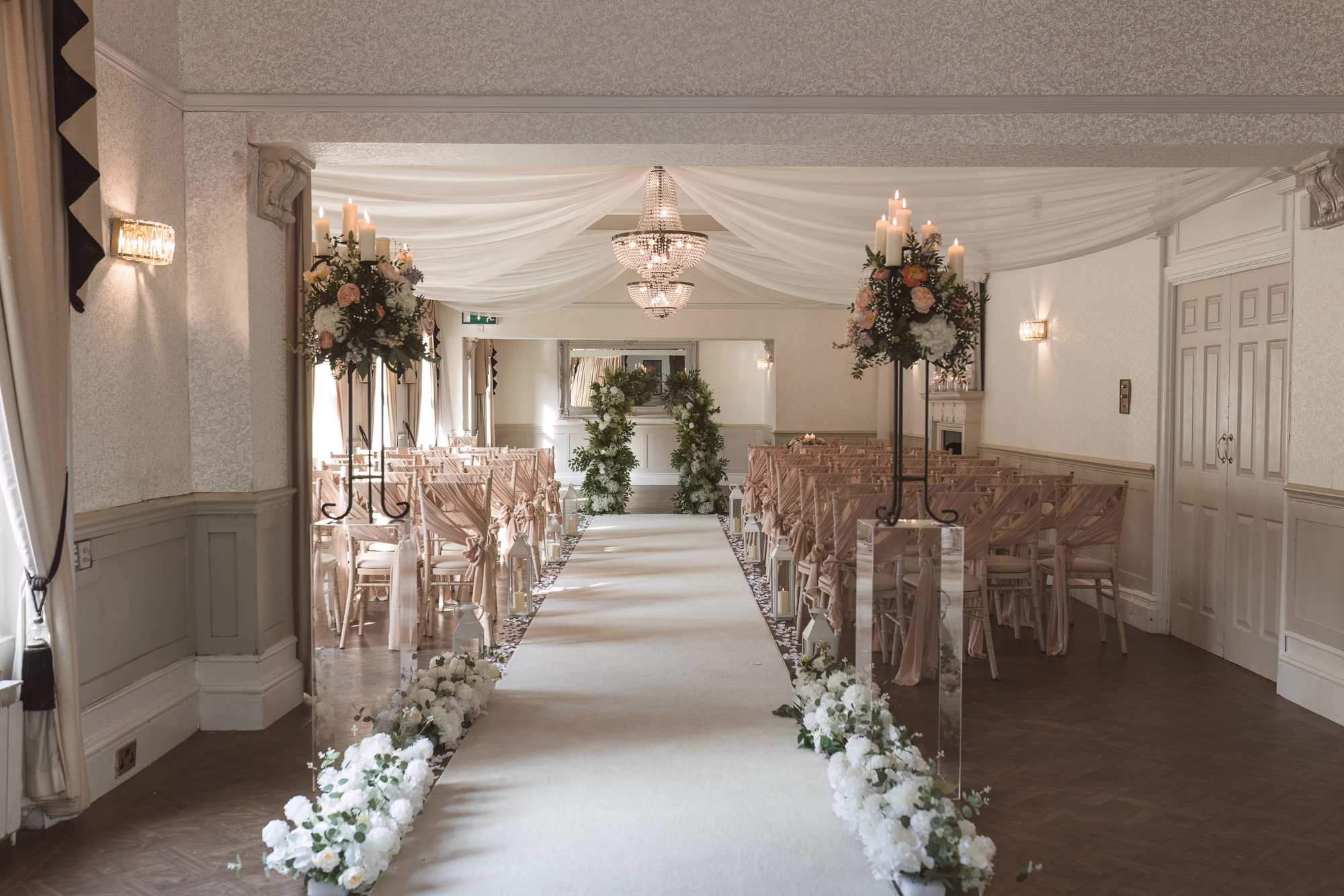 Elegant indoor wedding ceremony setup with floral aisle and romantic decor at a Yorkshire wedding venue