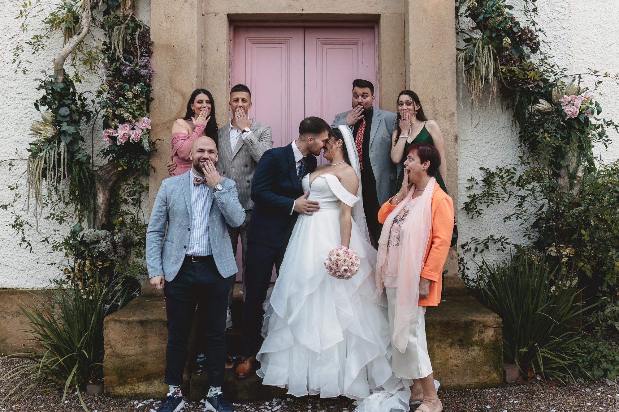 Fun and candid wedding group photo with bride, groom, and family outside a Yorkshire wedding venue.