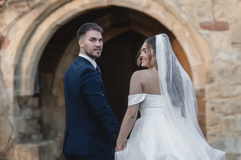 Romantic wedding portraits under stone archway in Leeds West Yorkshire