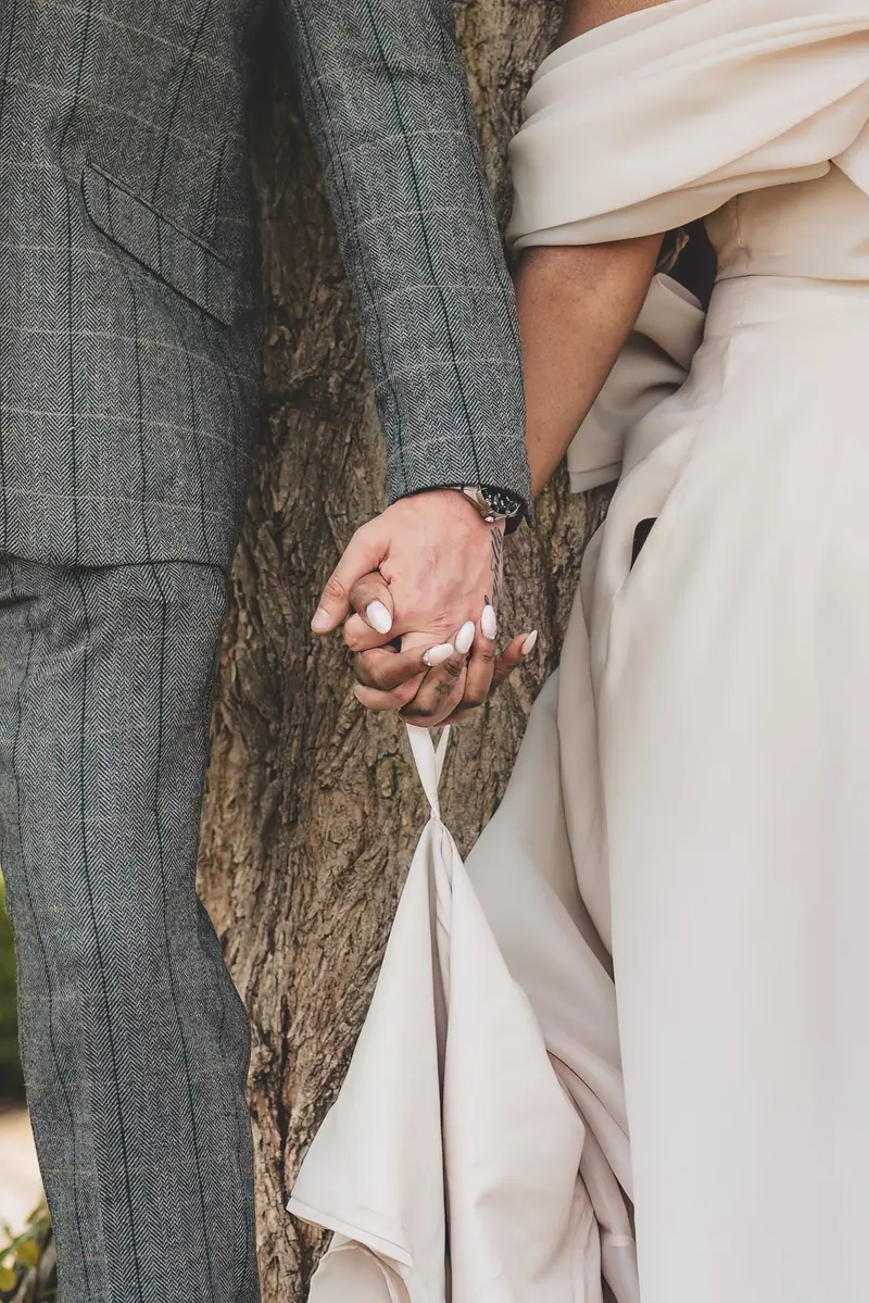 Close up of bride and groom holding hands during romantic wedding portraits