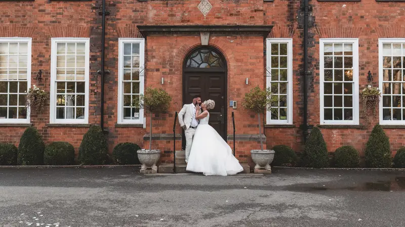 Romantic couple portrait outside red brick manor wedding venue