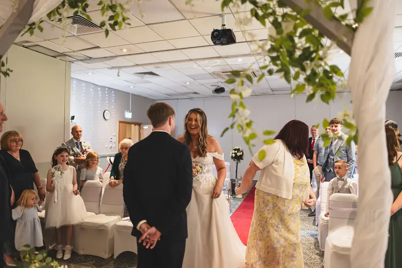 Bride walking down the aisle during an emotional indoor wedding ceremony