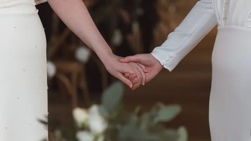 Lesbian wedding couple holding hands during emotional ceremony in Yorkshire