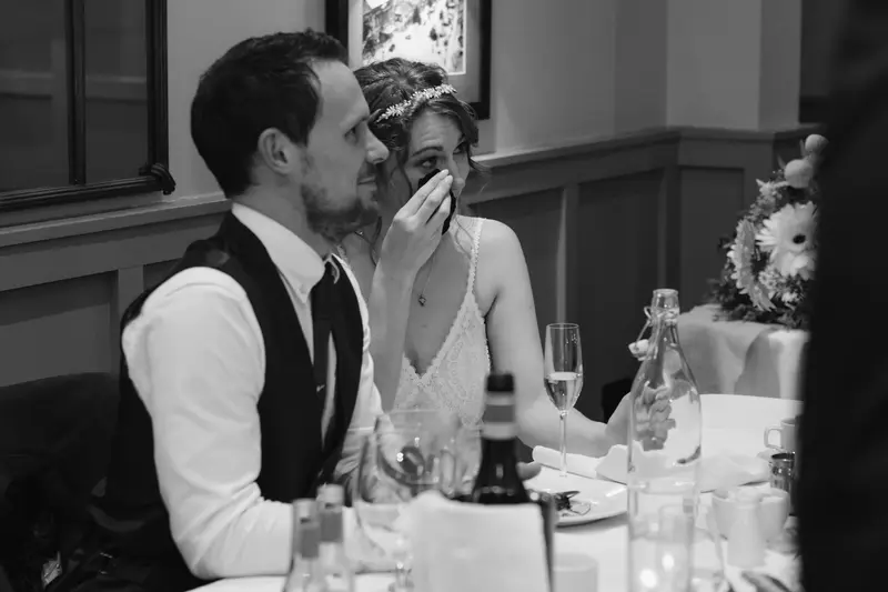 Black and white documentary wedding speech reaction with emotional bride and groom