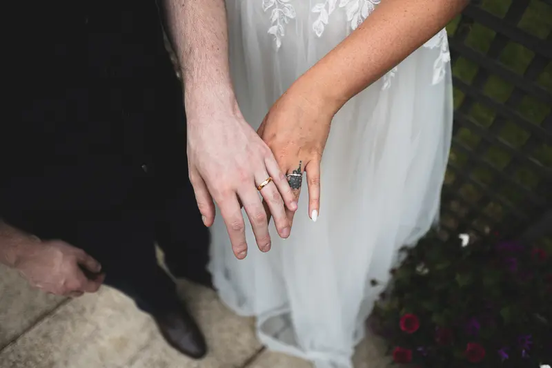 Close up wedding photograph of the bride's dress and wedding rings