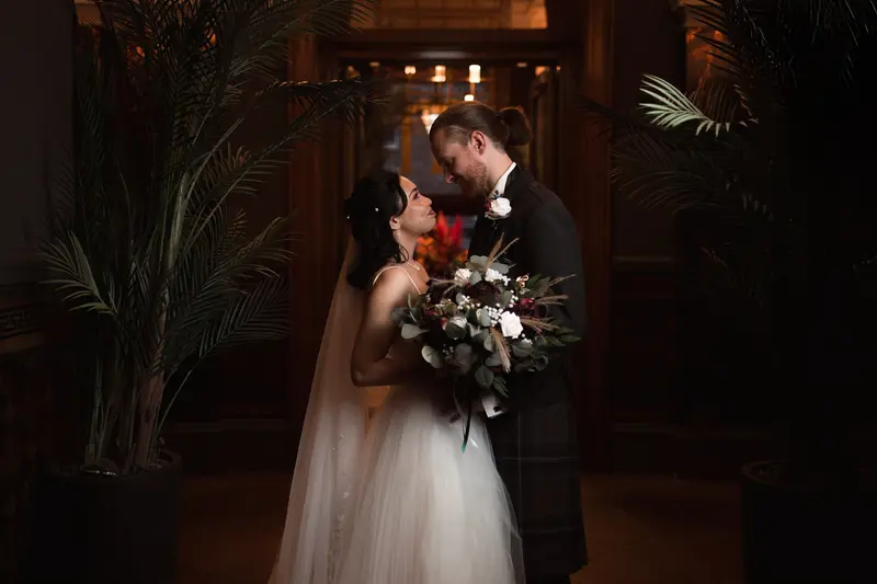 Romantic newlywed portrait framed by luxury hotel interiors, dark and moody wedding photography