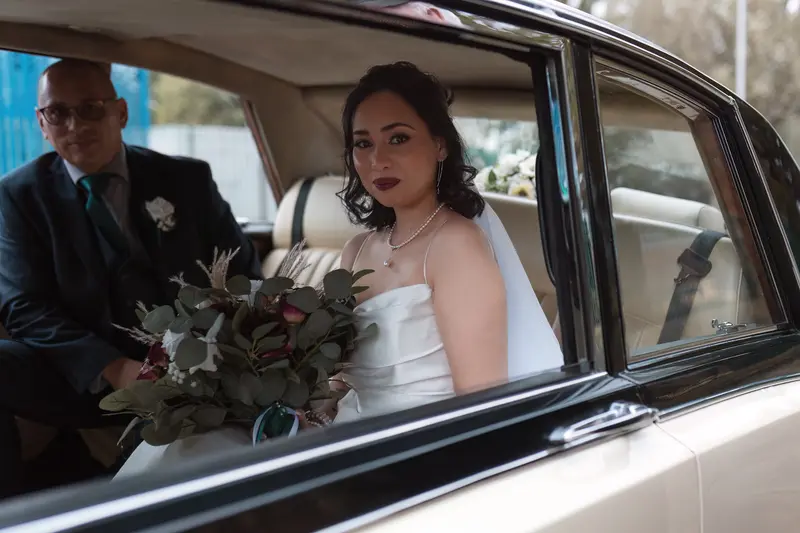 Documentary bridal arrival photography in Yorkshire with vintage wedding car and natural emotion