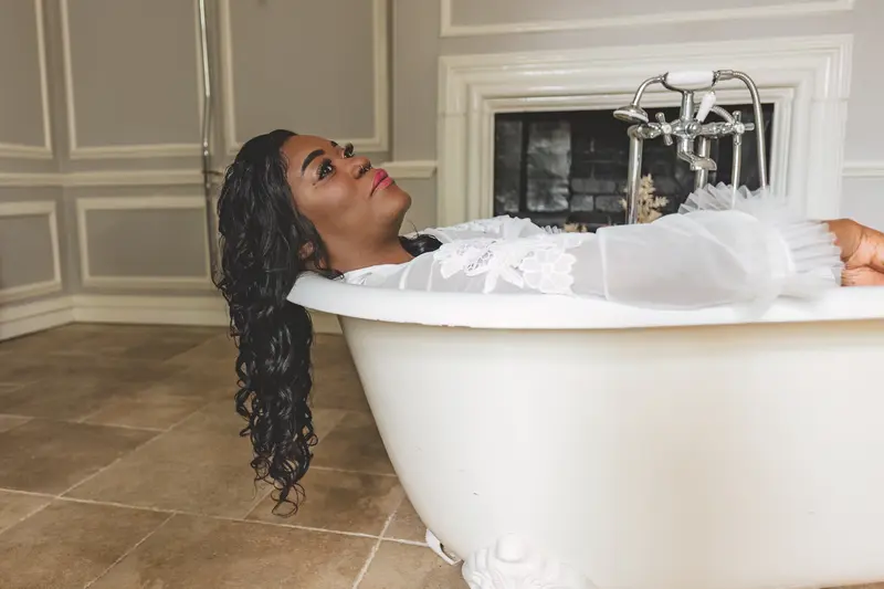 Creative bridal portrait of the bride lying in a bath before the wedding ceremony
