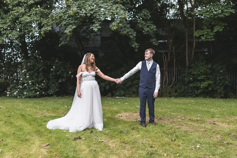 Bride and groom holding hands during relaxed outdoor wedding portraits