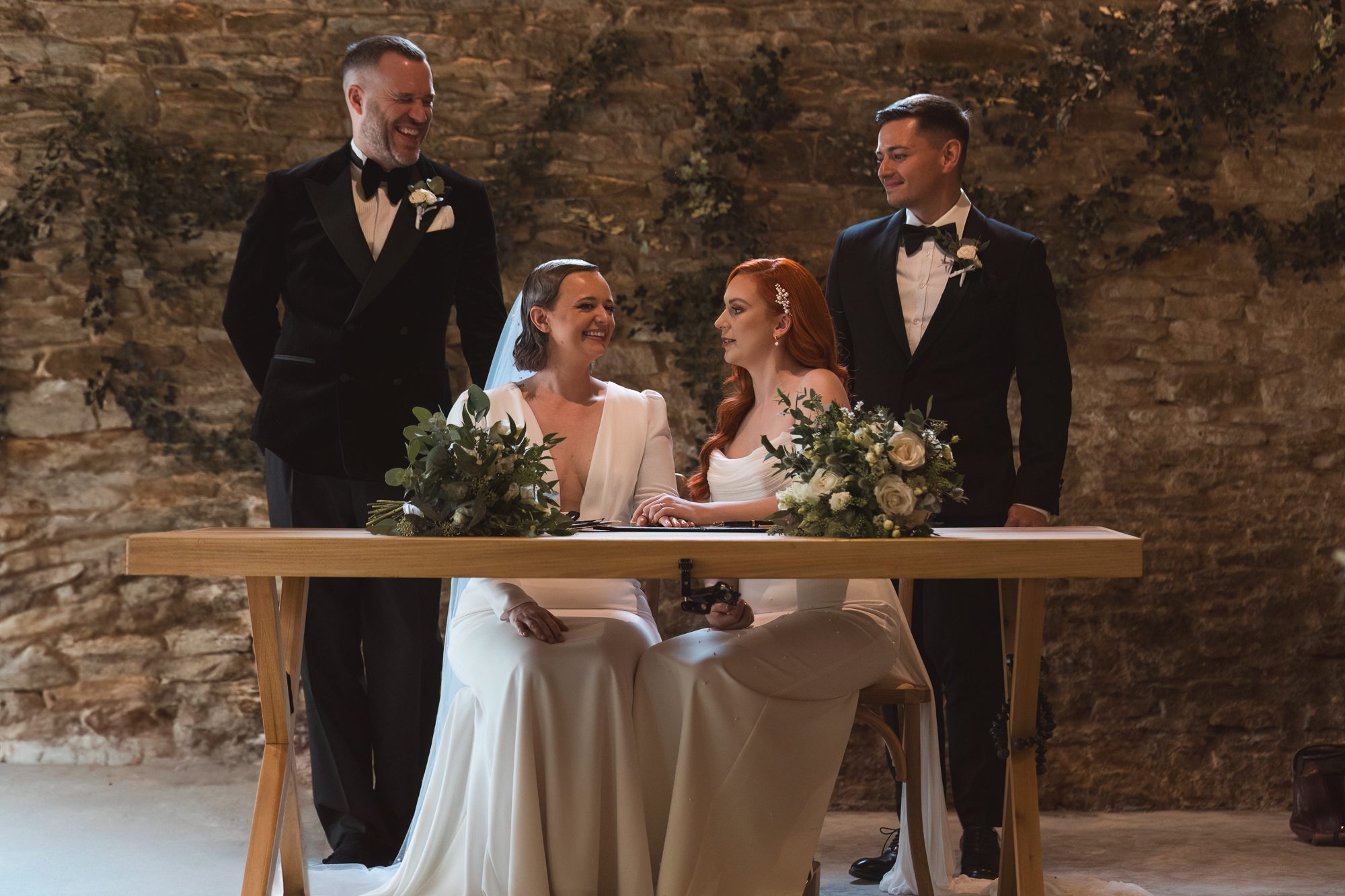 Romantic lesbian wedding ceremony signing at rustic Yorkshire wedding venue