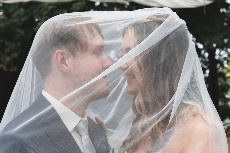 Romantic bride and groom portrait beneath the wedding veil