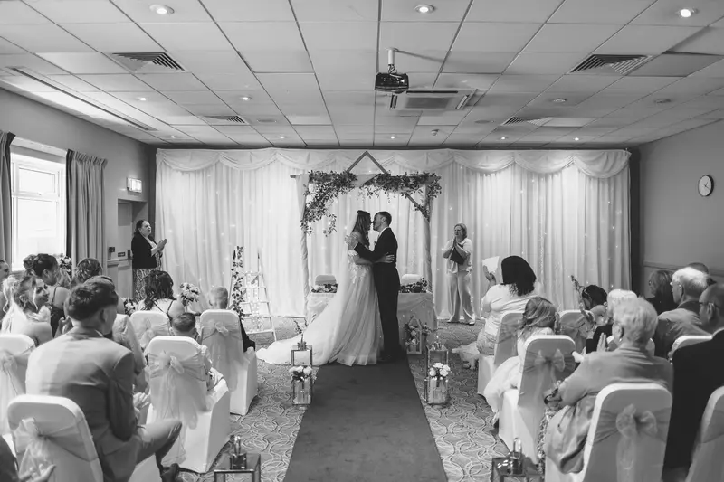 Black and white documentary wedding ceremony with bride and groom at the altar