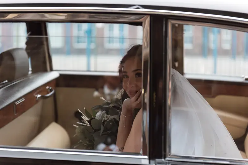 Elegant bride portrait inside classic wedding car in Yorkshire, luxury documentary wedding photographer