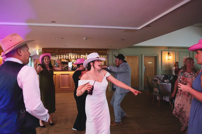 Fun wedding party dancing with cowboy hats at Yorkshire wedding reception