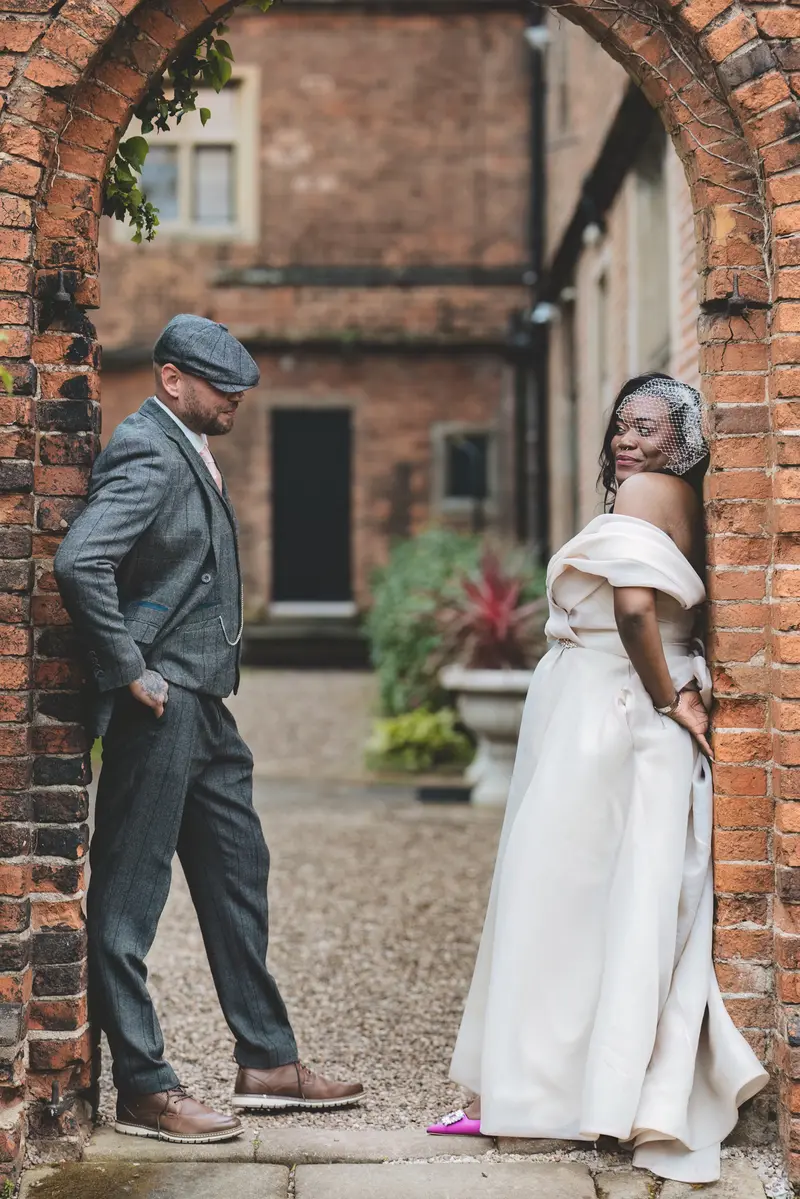 Bride and groom posing playfully outside the wedding venue during relaxed portraits