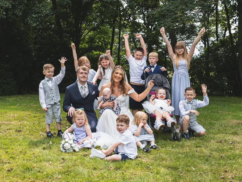 Fun group wedding photo with family and children celebrating outdoors