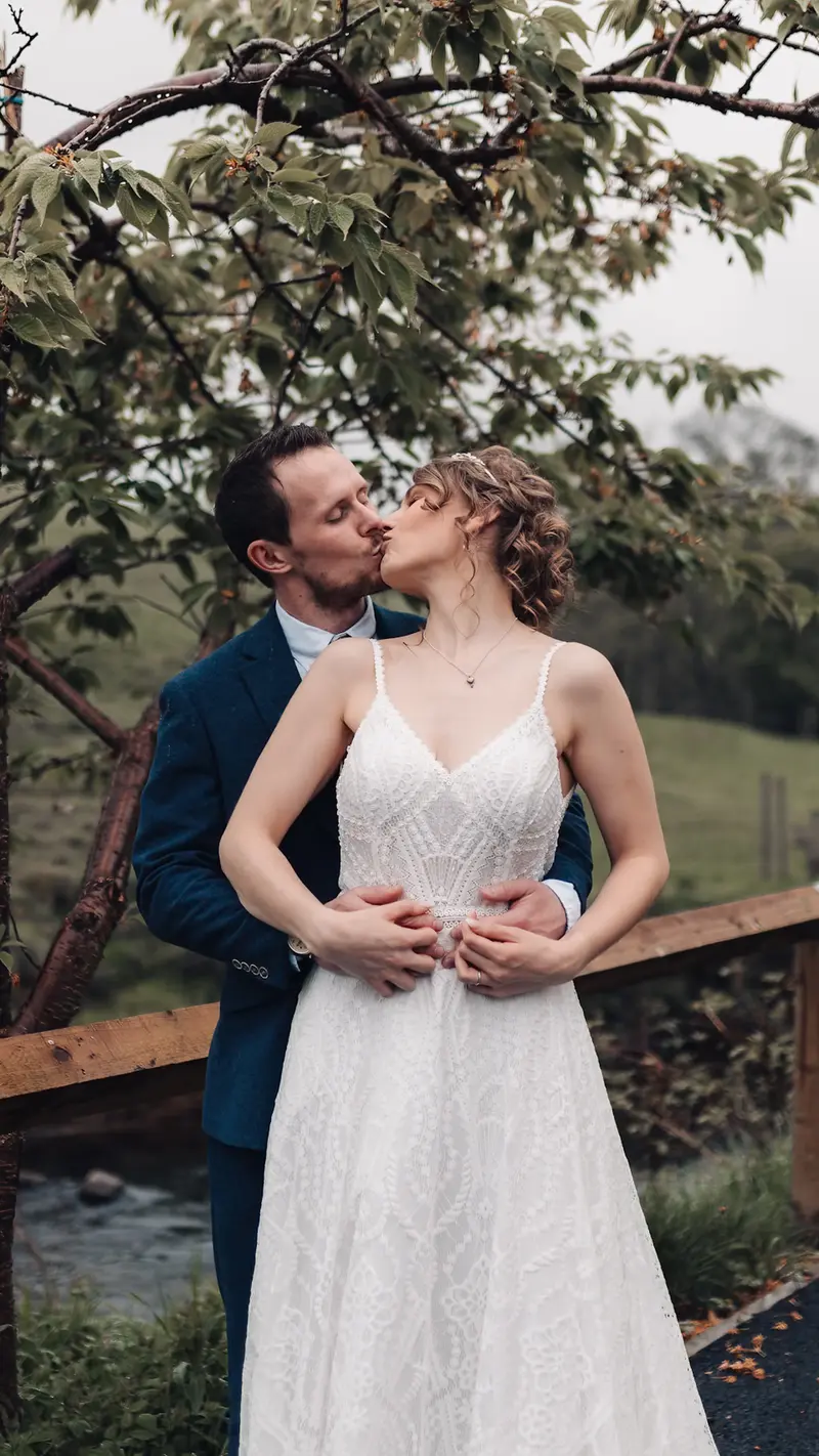 Cinematic wedding kiss under tree with documentary style photography