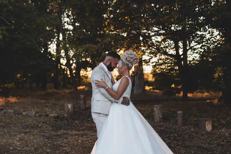 Golden hour wedding portrait with bride and groom in woodland sunset