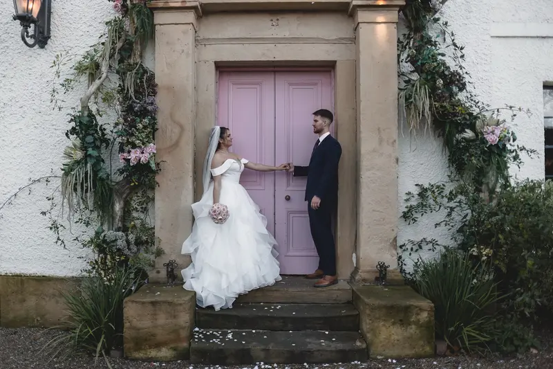 Romantic couple portrait outside elegant garden wedding venue entrance