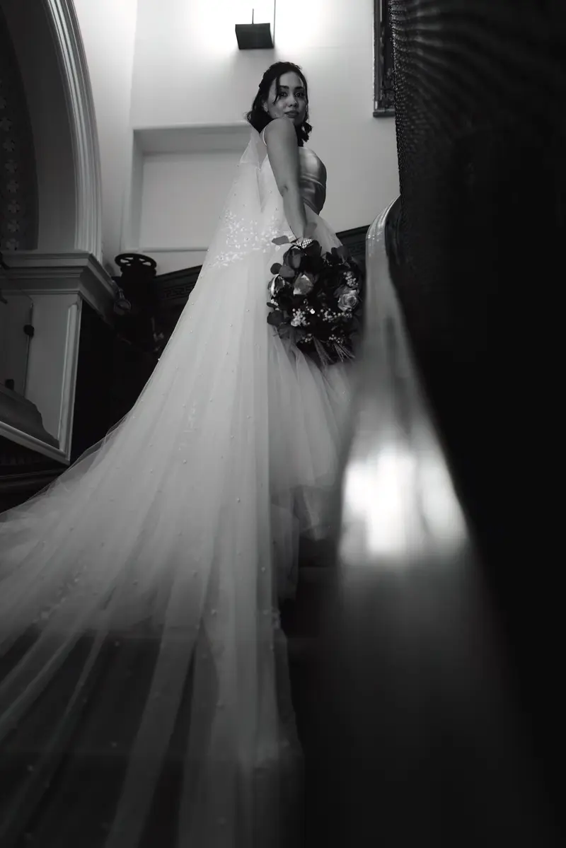 Dramatic bridal portrait with veil and bouquet, cinematic black and white wedding photography UK