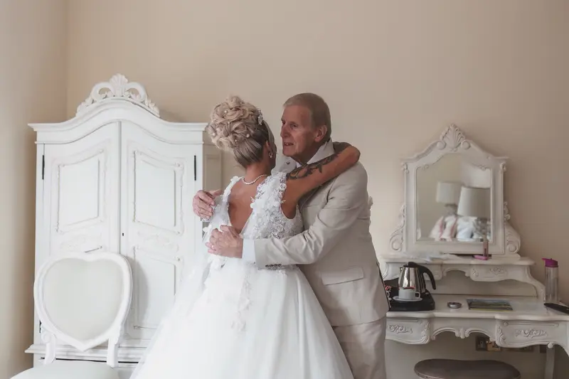 Heartfelt father and bride hug during emotional wedding morning moments
