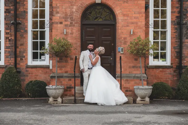 Romantic bride and groom portrait outside manor house, elegant UK wedding photography