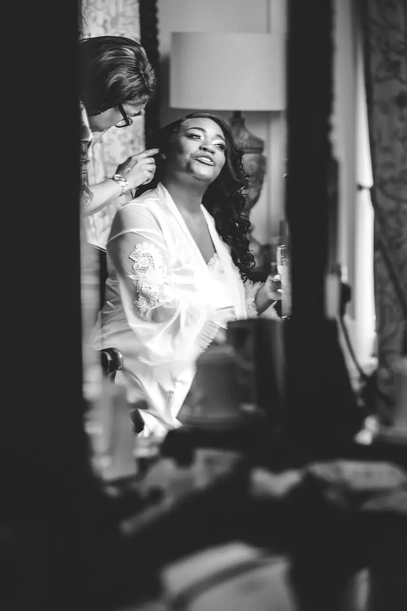Black and white candid bridal preparation moment with bridesmaids before the ceremony