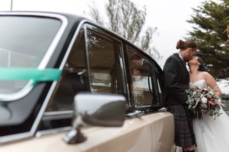 Romantic wedding couple beside vintage car in Liverpool, cinematic documentary wedding photography