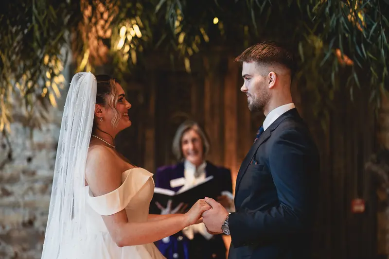 Bride and groom exchanging vows during an emotional indoor wedding ceremony with natural documentary photography