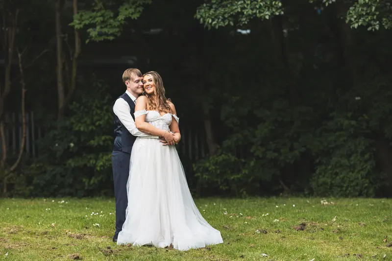 Natural wedding portrait of the bride and groom surrounded by woodland