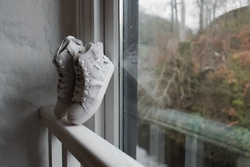 Bridal glitter trainers by window with natural light wedding detail photography