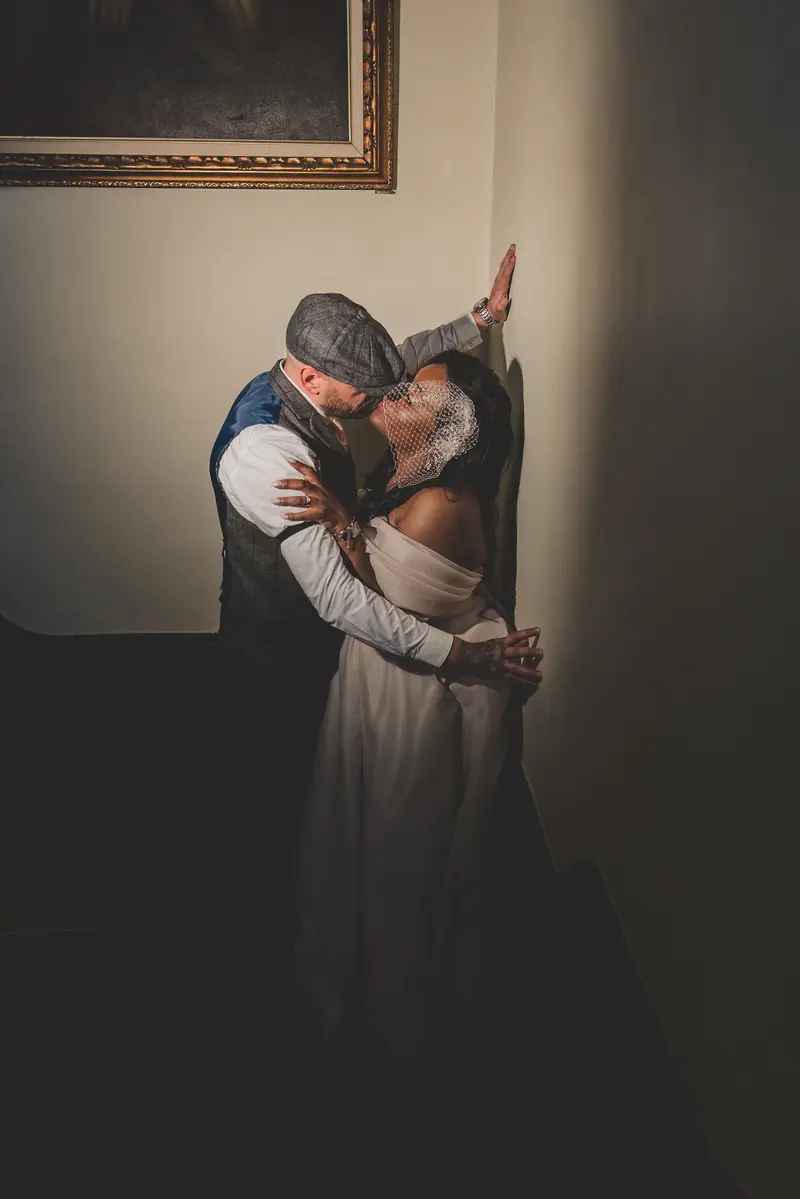 Romantic bride and groom portrait on a staircase in dramatic wedding light