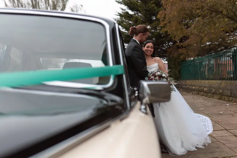 Candid newlywed portrait with classic wedding car, natural Liverpool wedding photographer