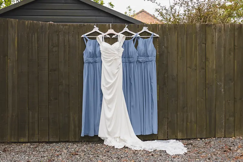 Bride and bridesmaids dresses hanging before wedding morning preparations