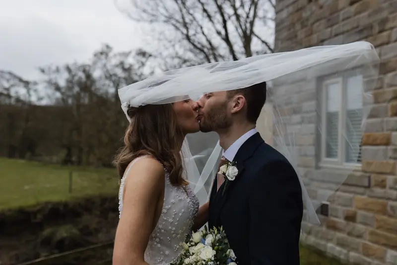 Romantic veil kiss portrait of bride and groom during countryside Yorkshire wedding photography session