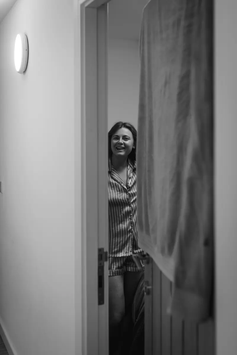 Black and white candid bridal preparation photo through doorway at Yorkshire documentary wedding