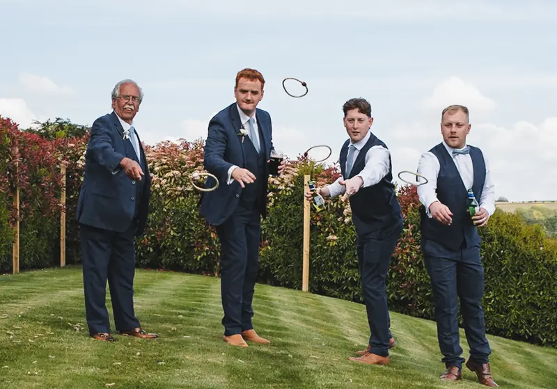Fun documentary wedding photography of groomsmen playing garden games at Yorkshire wedding venue