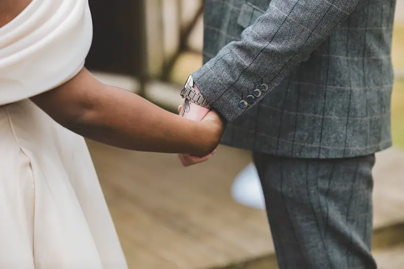 Close up of bride and groom holding hands during their wedding ceremony