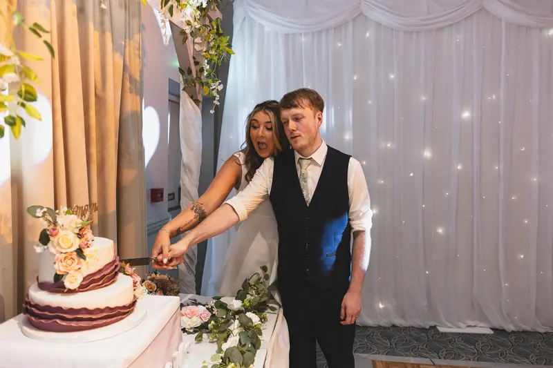 Bride and groom cutting their wedding cake during the evening reception