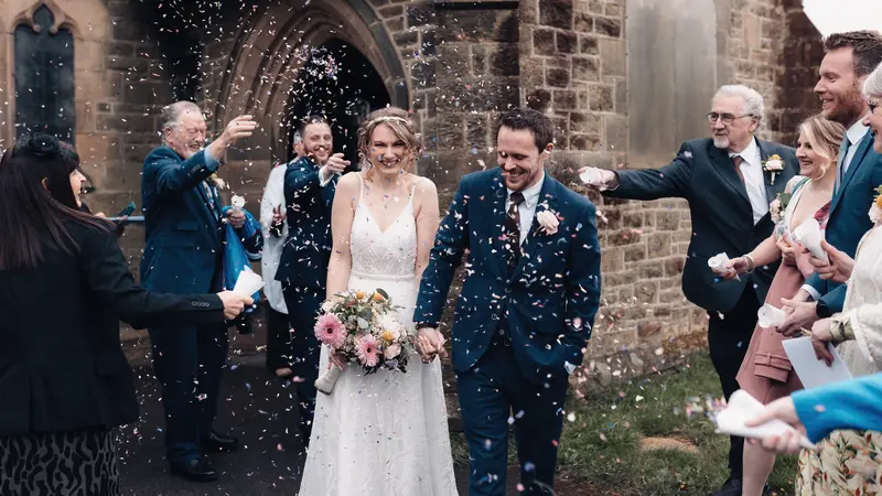 Joyful wedding confetti exit photographed in documentary wedding photography style Yorkshire