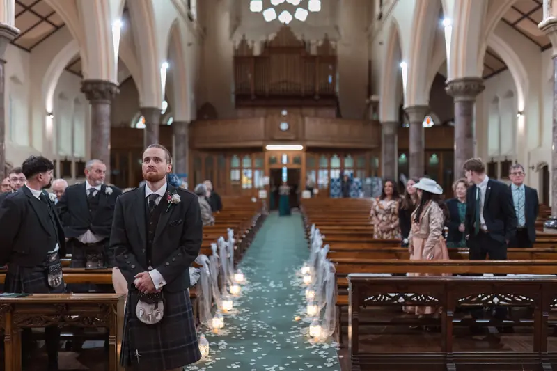 Groom waiting at altar during church ceremony captured by documentary wedding photographer Yorkshire