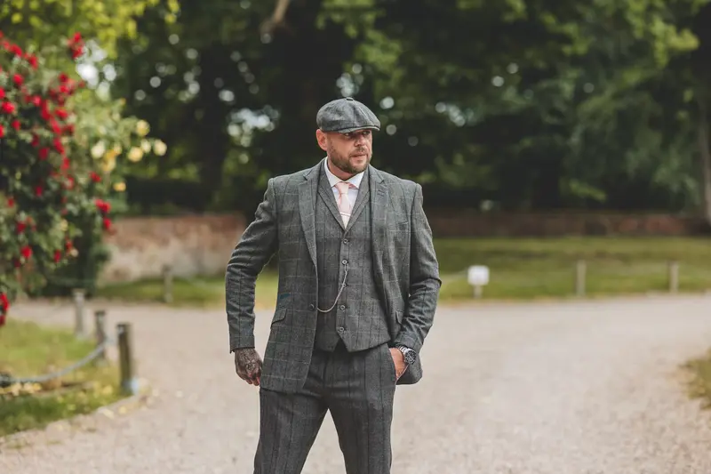 Groom walking through the venue gardens during relaxed wedding morning portraits