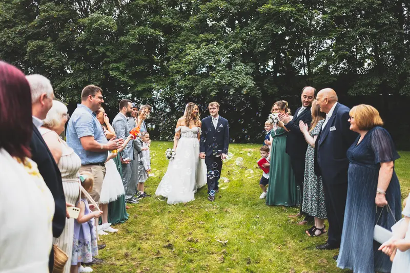 Wedding guests watching the bride and groom during an outdoor ceremony