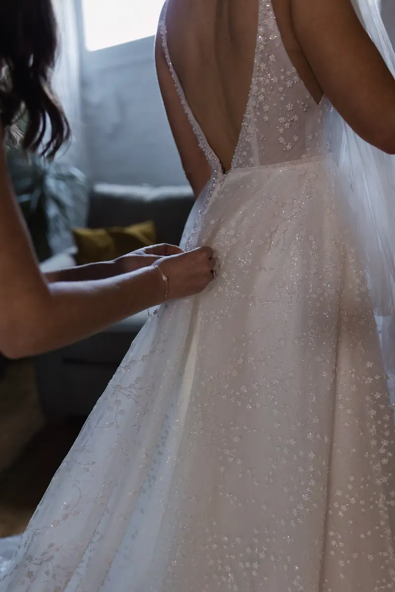Close up documentary bridal dress fastening moment at Yorkshire wedding