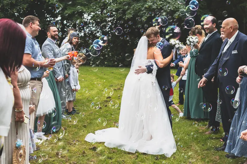 Bride and groom walking through a joyful confetti exit after their ceremony