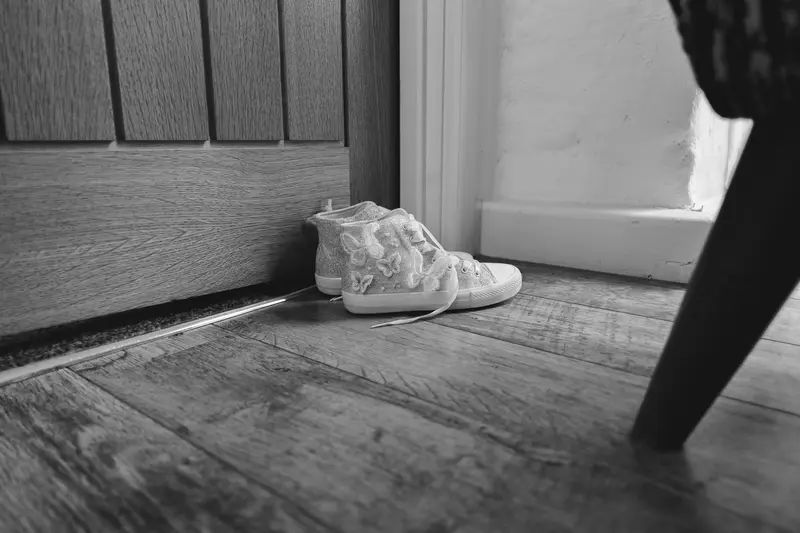 Black and white wedding detail photo of flower girl shoes during bridal preparations at Yorkshire wedding venue