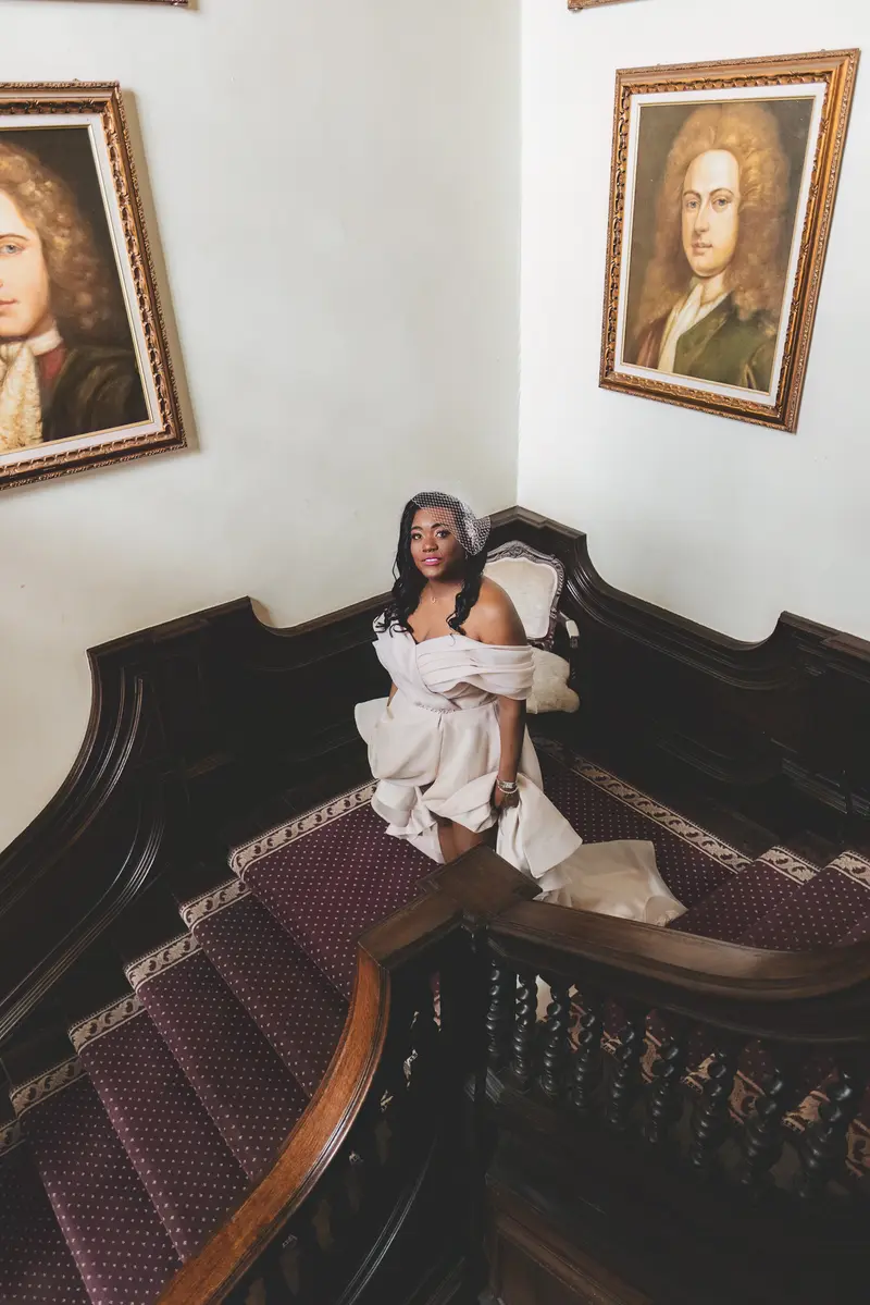 Bride relaxing on a vintage staircase during elegant bridal portraits